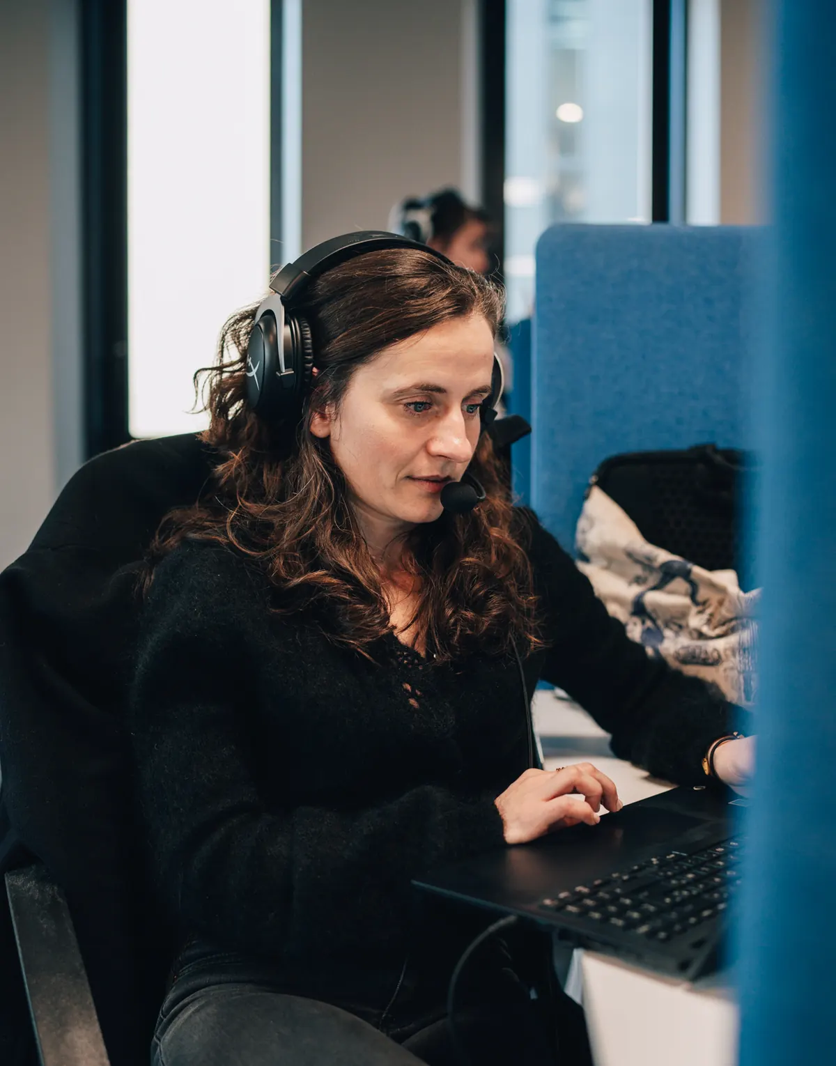 Une conseillère de l’équipe Simplifia au casque, devant son ordinateur